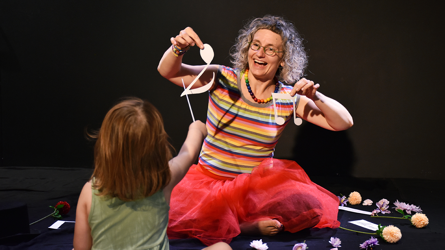 Gudrun Stadlbauer-Mtetwa mit einem Kind beim Dirigieren