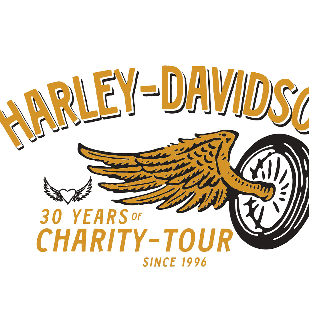Ein Logo auf weißem Hintergrund mit dem geschwungenen, ockerfarbenen Schriftzug „HARLEY-DAVIDSON“. Darunter befindet sich eine Grafik, die ein Motorradrad mit einem großen, ausgestreckten Flügel zeigt. Im linken unteren Bereich steht der Text „30 YEARS OF CHARITY-TOUR SINCE 1996“ zusammen mit einem kleinen Logo eines geflügelten Herzens.